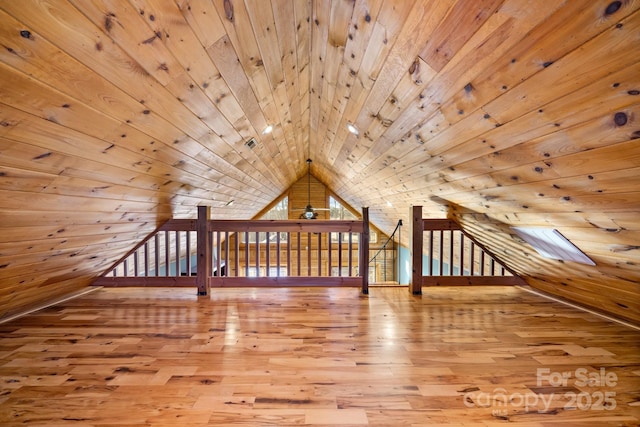 additional living space featuring wooden ceiling, wood walls, a skylight, and hardwood / wood-style flooring