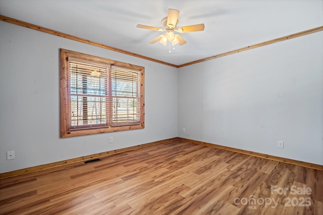 empty room featuring ceiling fan, ornamental molding, and light hardwood / wood-style flooring