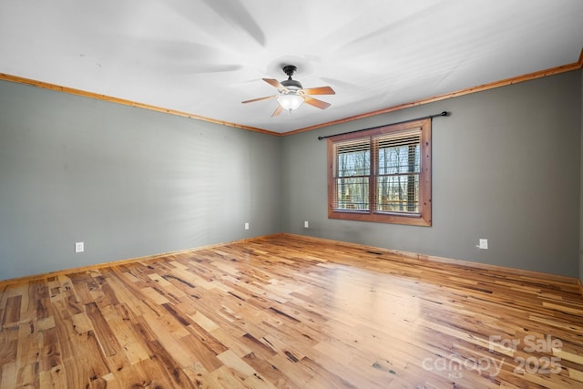 empty room featuring ornamental molding, ceiling fan, and light wood-type flooring