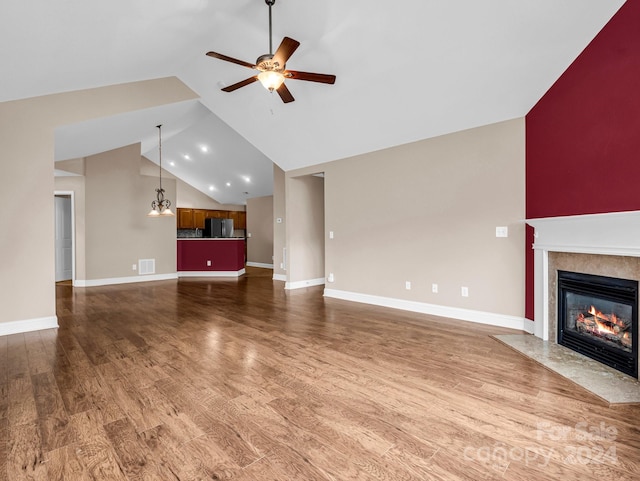 unfurnished living room with ceiling fan, dark hardwood / wood-style floors, and high vaulted ceiling