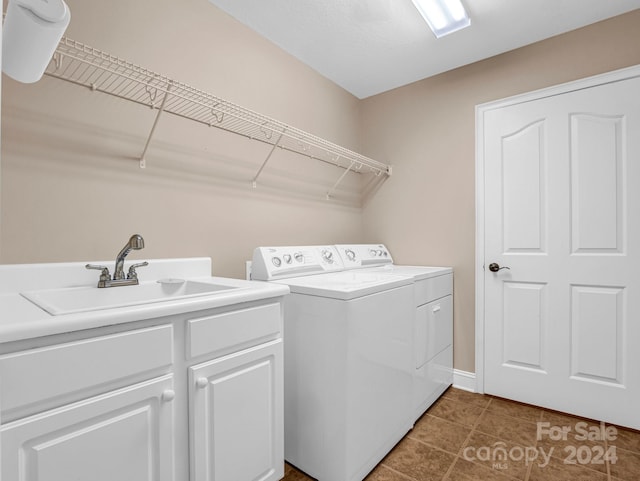 clothes washing area with cabinets, sink, independent washer and dryer, and dark tile patterned floors