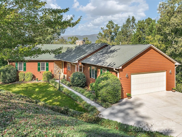 view of front of home with a front lawn, a garage, and a mountain view