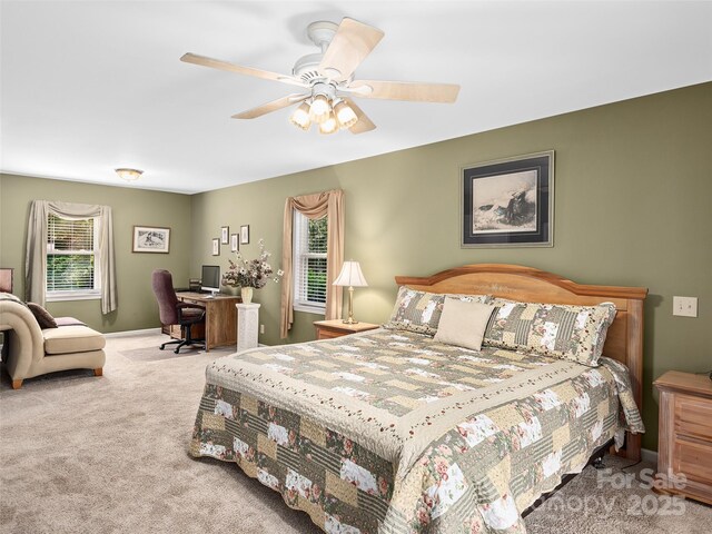 carpeted bedroom featuring multiple windows and ceiling fan