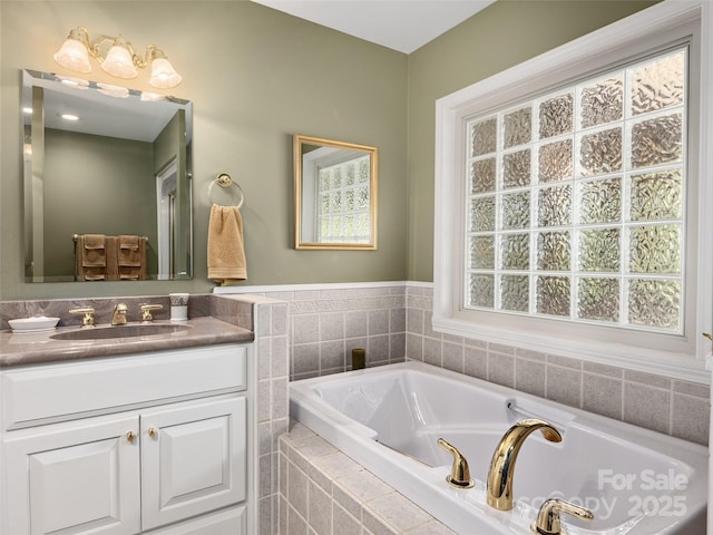 bathroom featuring vanity and tiled bath