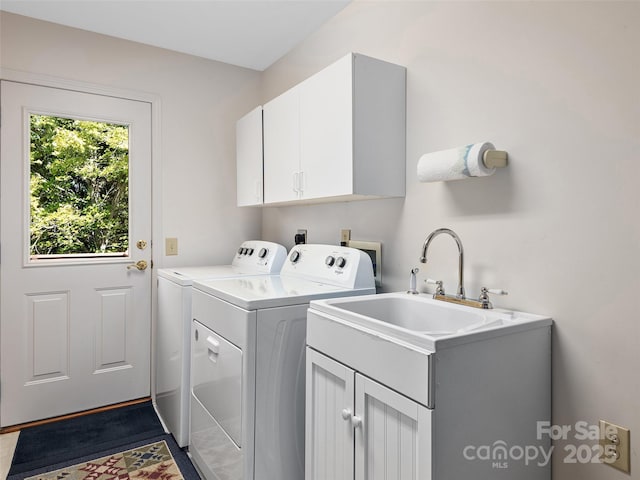 clothes washing area with sink, cabinets, and independent washer and dryer