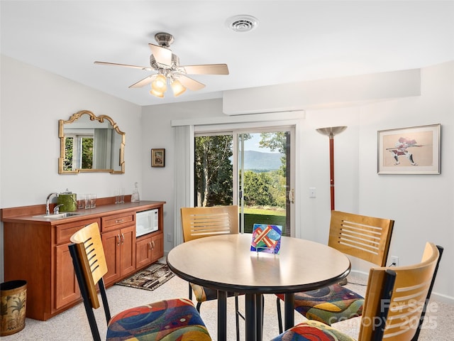 dining area featuring ceiling fan and sink