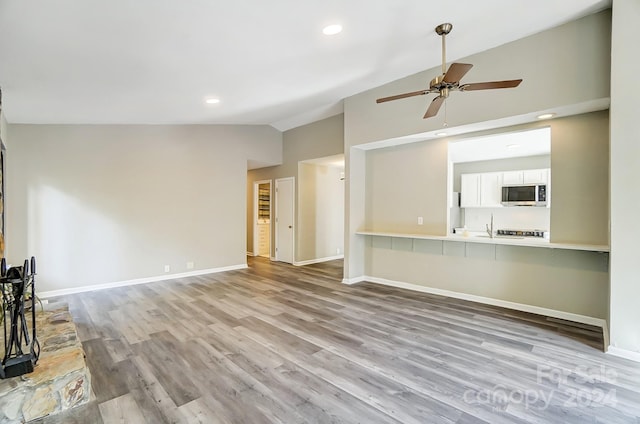 unfurnished living room with high vaulted ceiling, light hardwood / wood-style floors, and ceiling fan