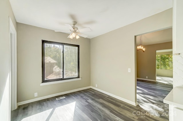 unfurnished room with a wealth of natural light and dark hardwood / wood-style flooring