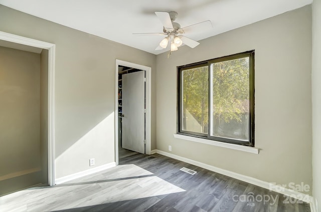 unfurnished bedroom with hardwood / wood-style flooring, ceiling fan, and a closet