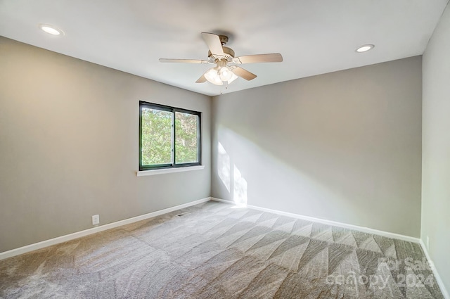 carpeted spare room with ceiling fan