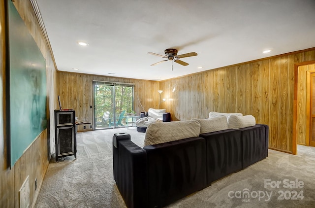 living room with light colored carpet, wooden walls, crown molding, and ceiling fan