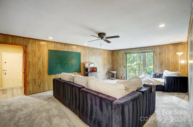 living room featuring wood walls, ceiling fan, and crown molding