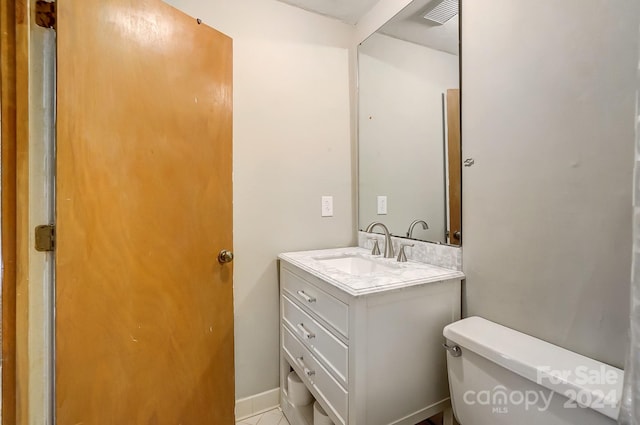 bathroom featuring vanity, tile patterned floors, and toilet