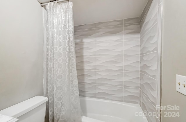 bathroom featuring toilet and shower / tub combo with curtain