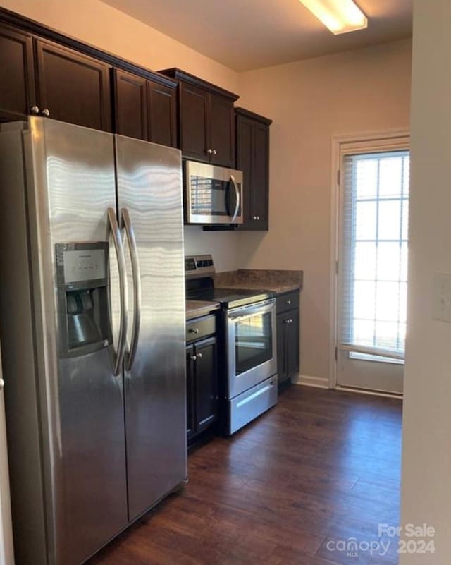 kitchen featuring dark wood-type flooring, appliances with stainless steel finishes, and dark brown cabinetry