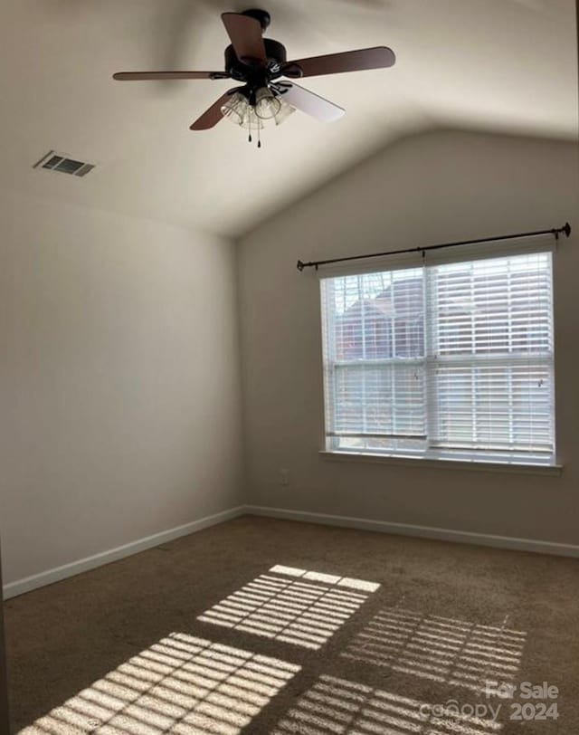 carpeted spare room with ceiling fan and lofted ceiling