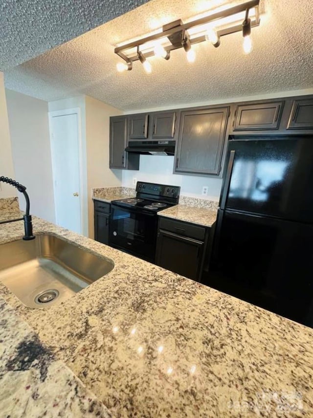 kitchen featuring track lighting, dark brown cabinets, a textured ceiling, black appliances, and sink