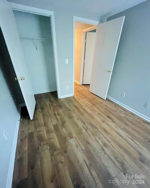 unfurnished bedroom featuring a closet and hardwood / wood-style floors