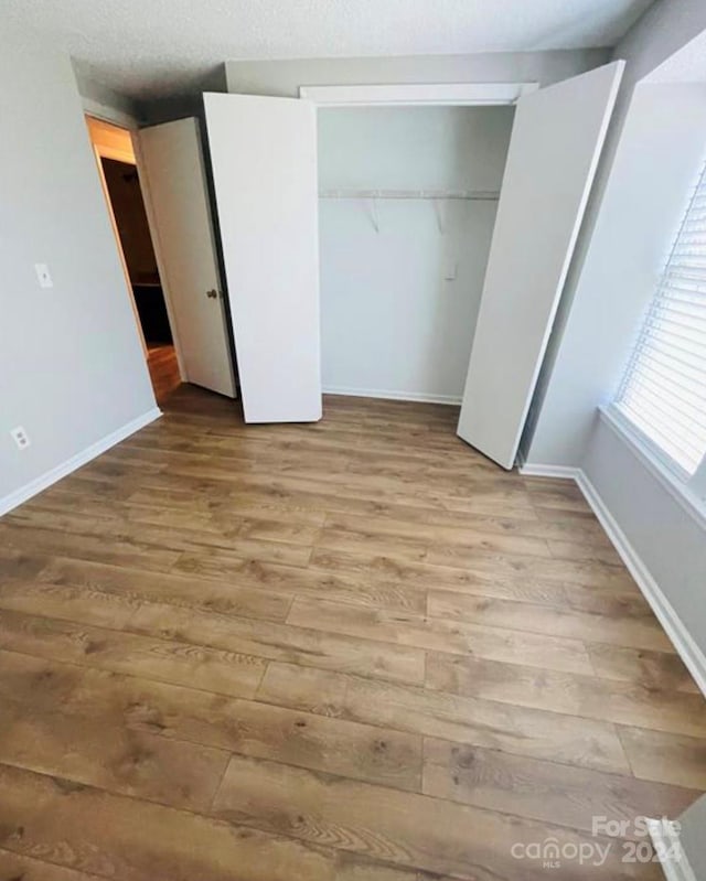 unfurnished bedroom featuring a closet and light hardwood / wood-style flooring