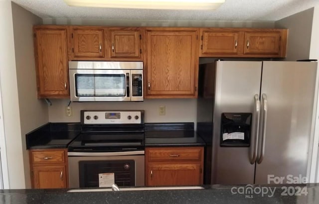 kitchen featuring stainless steel appliances and a textured ceiling