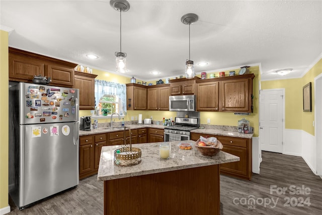 kitchen featuring dark wood-type flooring, stainless steel appliances, sink, and a kitchen island