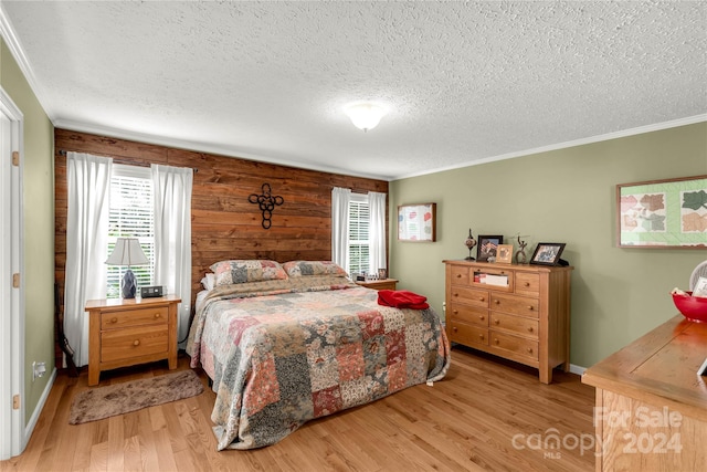 bedroom with light hardwood / wood-style floors, multiple windows, and crown molding