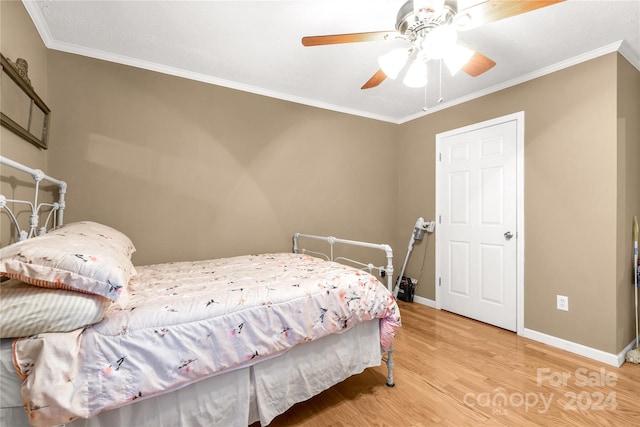 bedroom with crown molding, hardwood / wood-style flooring, and ceiling fan