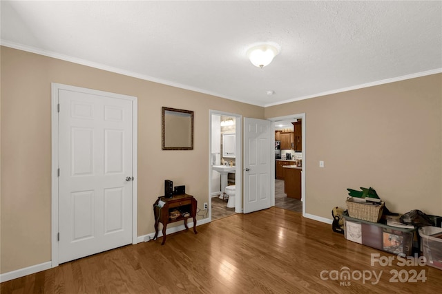 misc room featuring ornamental molding, a textured ceiling, and wood-type flooring