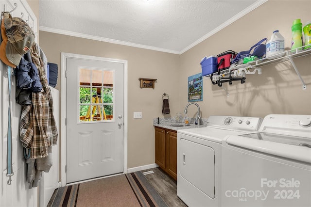 laundry area with washer and dryer, sink, a textured ceiling, dark hardwood / wood-style flooring, and cabinets