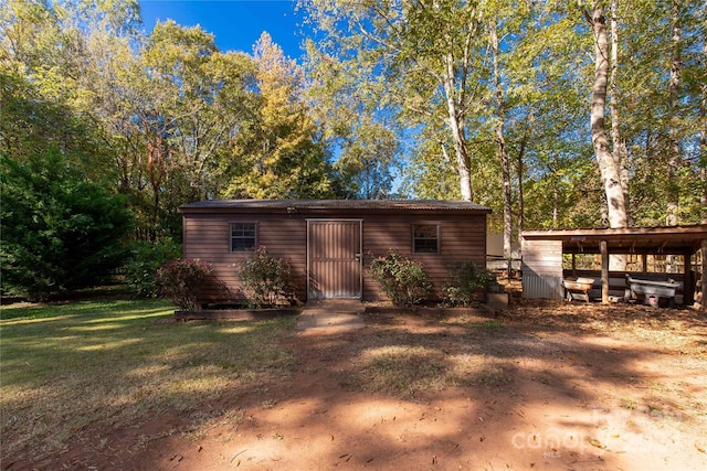 view of outdoor structure with a yard and a carport