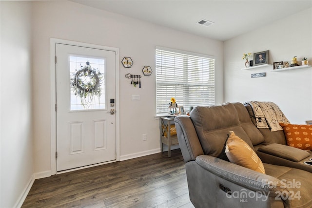 living room with dark wood-type flooring and a healthy amount of sunlight