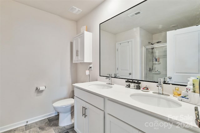 bathroom featuring vanity, toilet, and a shower with door