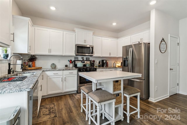 kitchen featuring dark wood-type flooring, stainless steel appliances, and white cabinets