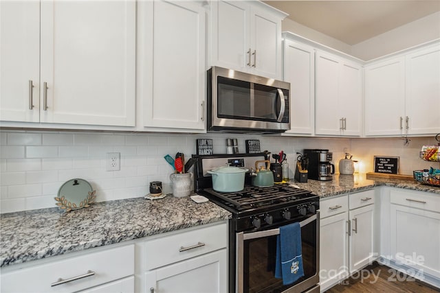 kitchen featuring light stone countertops, tasteful backsplash, appliances with stainless steel finishes, and white cabinets