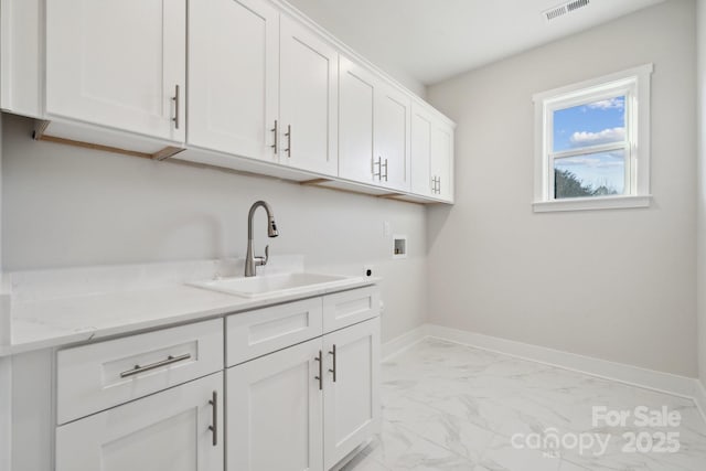 washroom featuring sink, hookup for a washing machine, hookup for an electric dryer, and cabinets