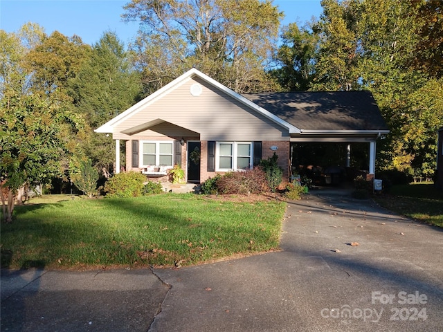 309 Rodoret St N, Valdese, NC 28690 - view of front facade with a front yard, aphalt driveway, brick siding, and an attached carport