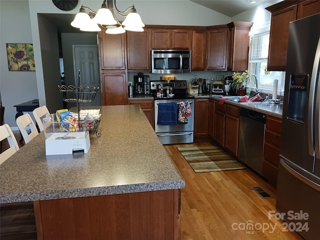 309 Rodoret St N, Valdese, NC 28690 - kitchen with wood finished floors, stainless steel appliances, a sink, a center island, and a notable chandelier