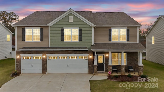 craftsman inspired home with a lawn, a porch, and a garage