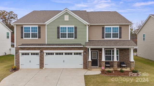 craftsman inspired home featuring a garage and a front yard