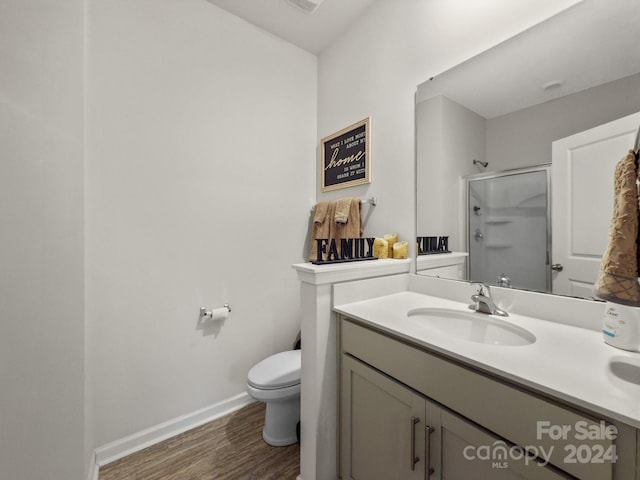 bathroom featuring vanity, toilet, an enclosed shower, and wood-type flooring