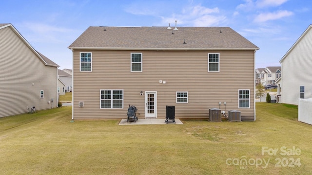 rear view of property featuring a yard, a patio area, and central air condition unit