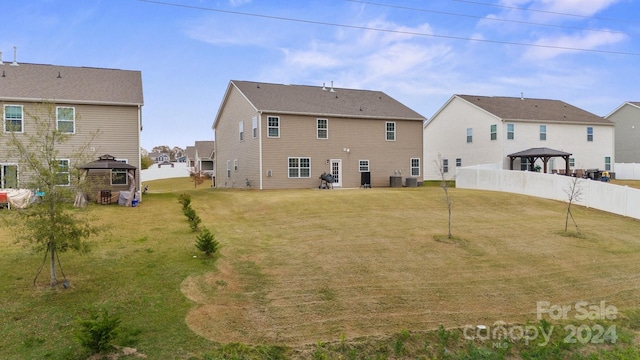 back of property with a gazebo and a lawn