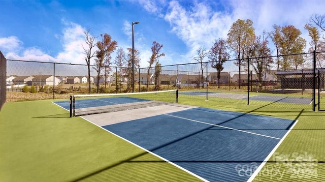 view of tennis court featuring basketball hoop