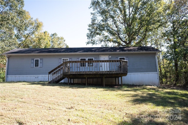 rear view of house with a deck and a lawn