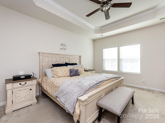 bedroom with a tray ceiling, light colored carpet, and ceiling fan