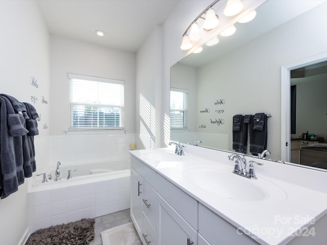 bathroom with vanity, a relaxing tiled tub, and tile patterned floors