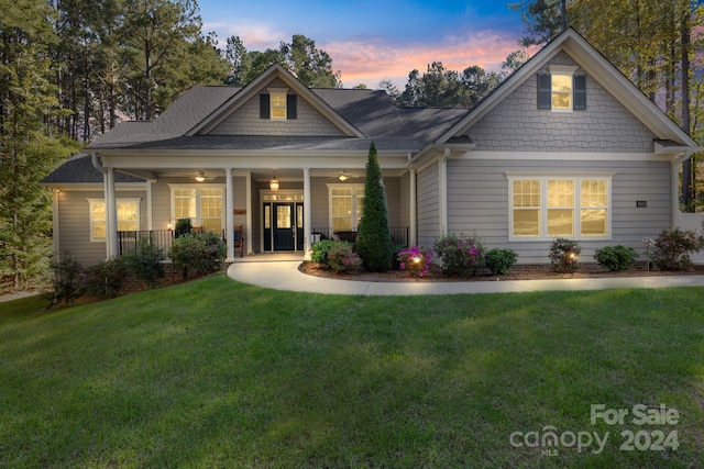 view of front of house featuring covered porch and a yard