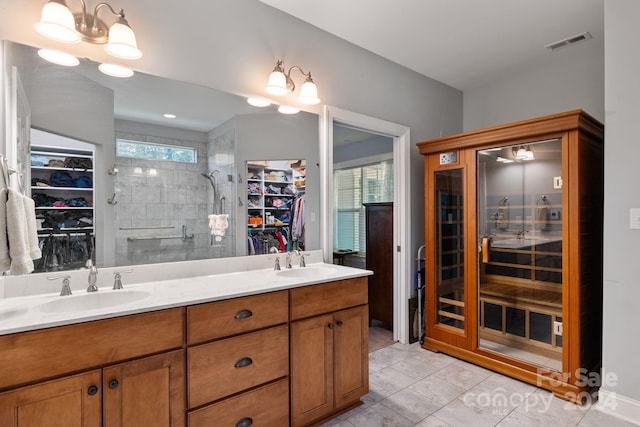 bathroom featuring vanity, a notable chandelier, walk in shower, and a healthy amount of sunlight