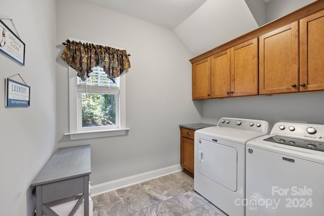 clothes washing area with cabinets and washing machine and clothes dryer