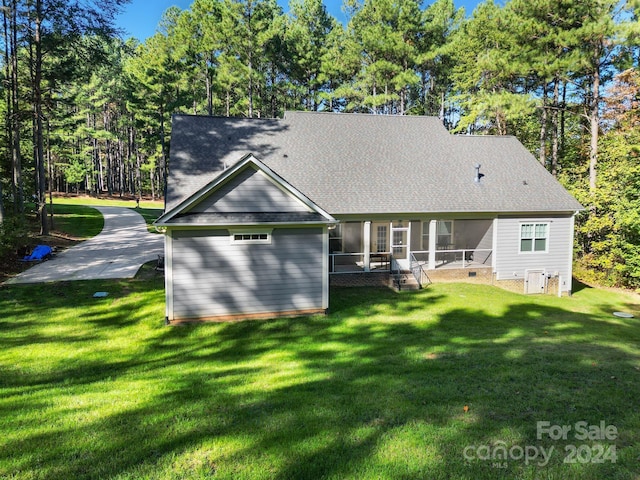 back of property featuring a lawn and a sunroom